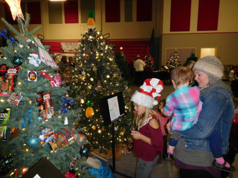 A family admires Christmas trees, decorated in themes inspired by Star Wars and holiday traditions from around the world, at the 2017 Washougal Festival of Trees. This year's festival, which benefits Washougal schools, will be held Dec.