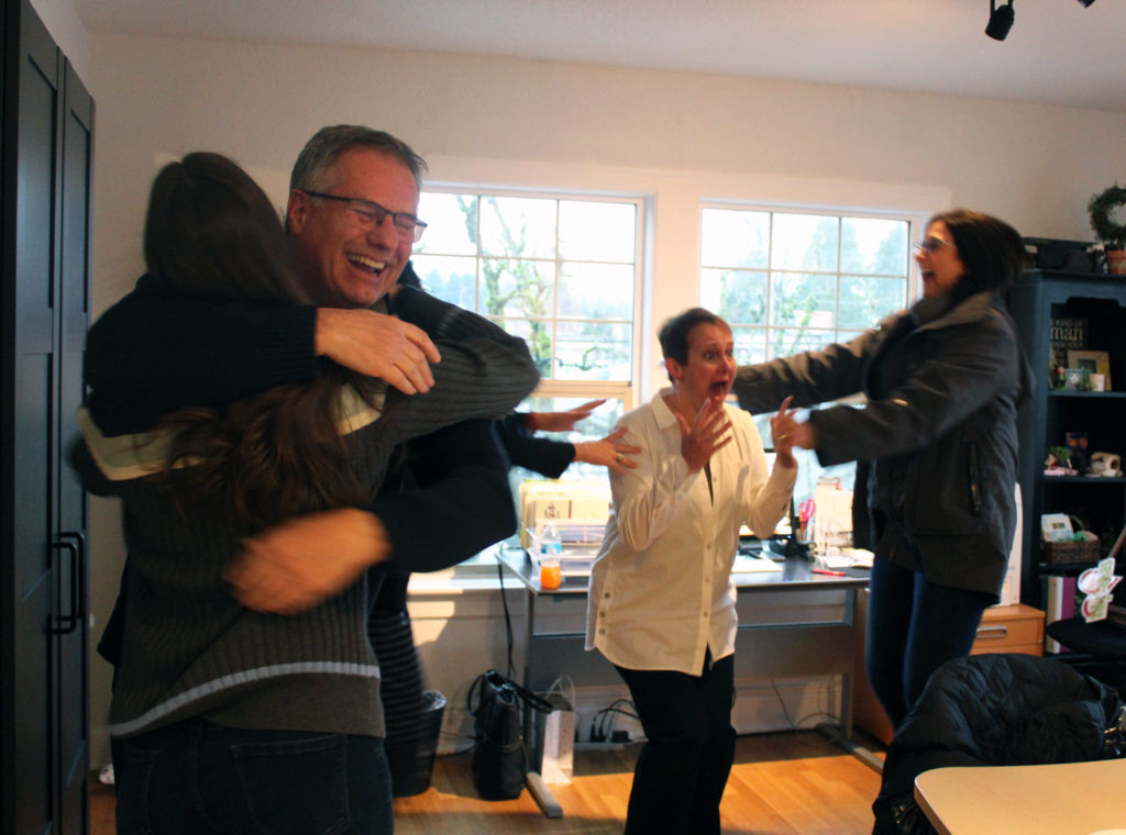 Members of the Downtown Camas Association (DCA), including Camas Parks and Recreation Chair Randy Curtis (second from left), Maria Maria Gonser, owner of Attic Gallery (left), DCA Executive Director Carrie Schulstad (second from right) and Arktana owner Ann Matthews (right) react with shock and joy Tuesday morning after Camas was named one of 10 cities in the running for the web series 