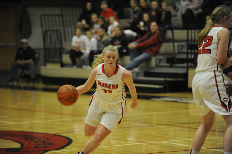 Point guard Haley Hanson takes advantage of a screen from Faith Bergstrom (right) and drives to the hoop against the Lions from West Linn.
