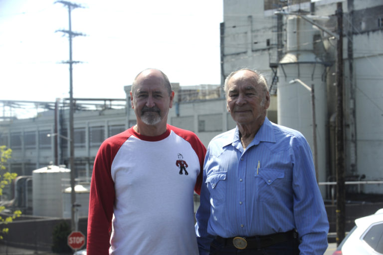 Kraig Nichols (left) and his father, Jerry Nichols (right), stand in the employee parking lot overlooking the Georgia-Pacific paper mill in downtown Camas in April 2018. Both men were part of the original start-up crew on the mill's No. 20 paper machine in 1984.