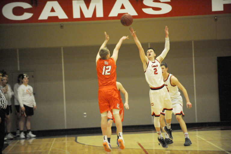 Carson Bonine challenges a Battle Ground Tiger shooter from deep in 3-point land on Jan.