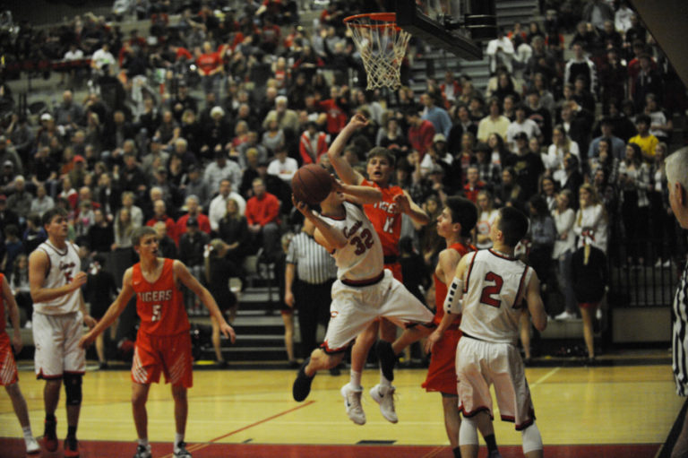 Camas senior guard Josh McPhun attempts an off-balance shot against a tough Battle Ground defense in the final game of the Papermakers&#039; season Jan.
