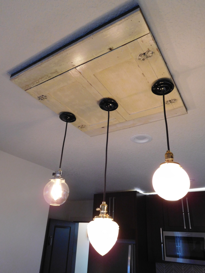 An original cabinet front from one of the 1925-built kitchens in the Blair Building is sanded and clear coated to be used like a ceiling medallion to add interest. Building co-owner Heidi Kramer said her and her husband, Bruce&#039;s style of incorporating found materials into the design and repurposing items throughout the build would probably frustrate most contractors.