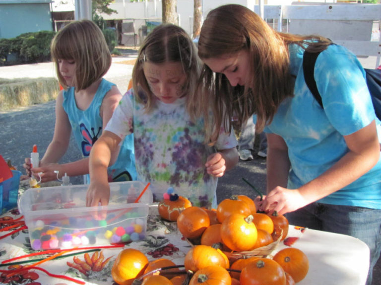 Children participate in pumpkin decorating during a Camas Farmer's Market Harvest Festival.