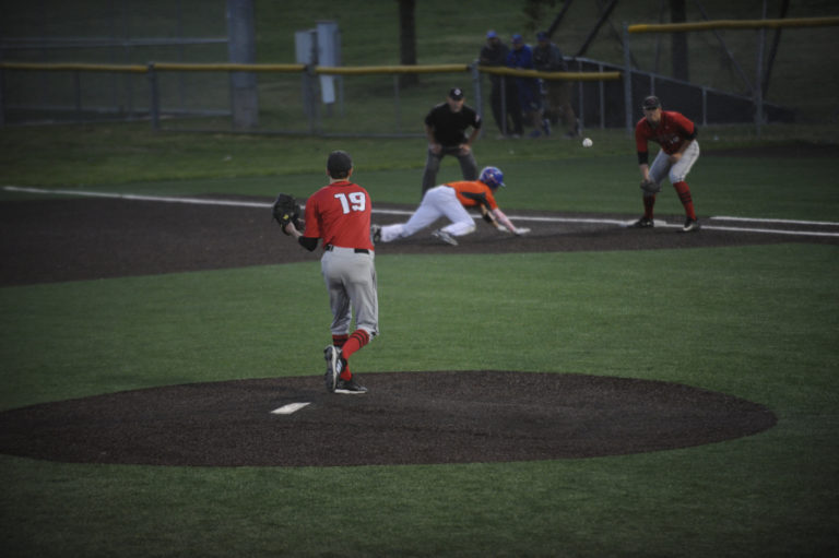 Riley Sinclair keeps a runner from Auburn Mountainview in check with quick throw to first base.