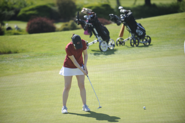 District Champion Emma Cox drains a ten foot putt at hole number 18 to score a 76 in day one of the tournament.