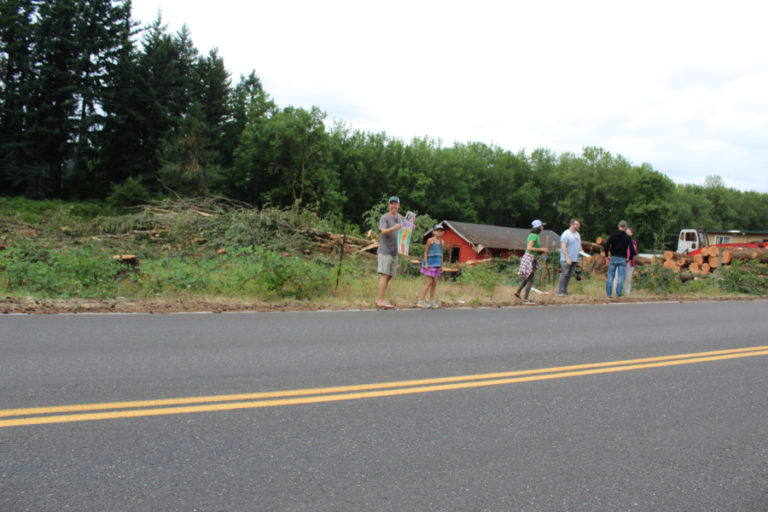 Members of the Camas Tree Protectors group stand next to a planned, 12-home development on Northwest 43rd Avenue in Camas on July 17, to protest a developer&#039;s decision to remove the majority of the property&#039;s trees.