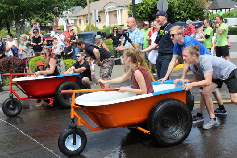 Two teams line up at the starting line for a bathtub race on Saturday, July 27.