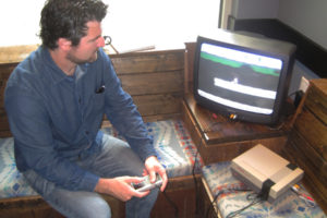 Chris Lincoln, of Washougal,  plays his video game, "Rollie," at the Washougal Coffee Company in July. Lincoln hopes to publish the game for the Nintendo Entertainment System in late 2019. (Doug Flanagan/Post-Record)