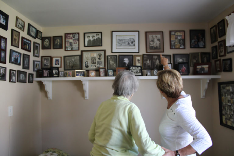 Cay Knapp Smith (left) and Rosemary Knapp (right) point out the many Camas historical figures in Knapp Smith's family photos on Aug.