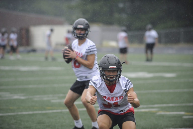 Camas High football players practice during a heavy downpour on Aug.