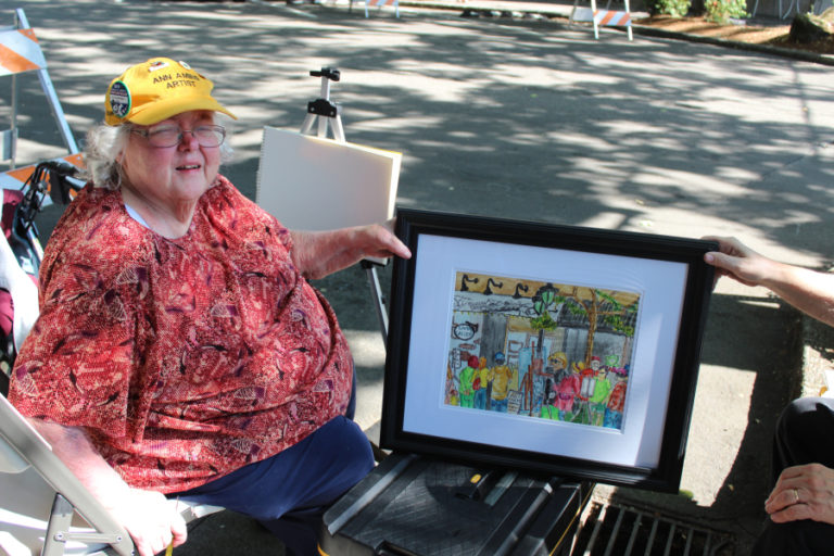 Artist Ann Amies shows her finished artwork during the 2018 Plein Air art event.