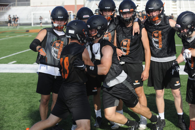 Brevan Bea (right) practices stripping the ball from senior Julien Jones during a Washougal High School football practice at Fishback Stadium.