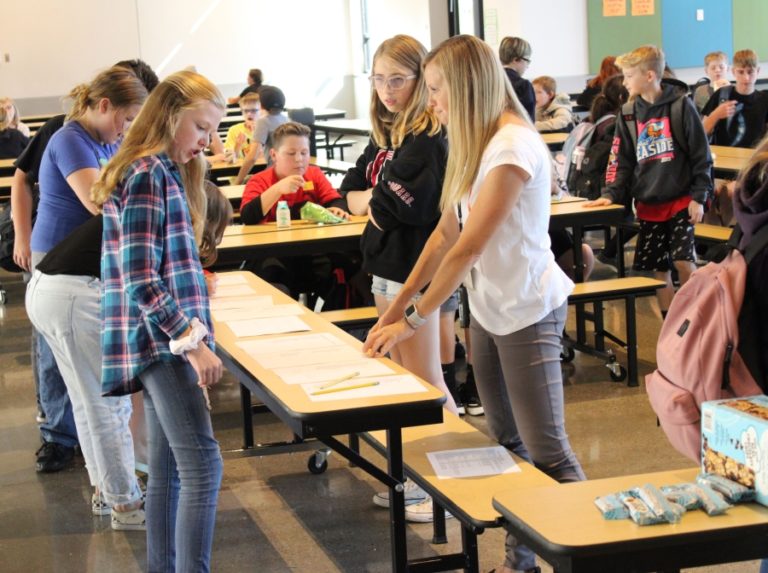 Jemtegaard Middle School student services assistant Tracey Stinchfield (right) helps students register for Club 8 activities on Thursday, Sept. 12 at Jemtegaard Middle School.