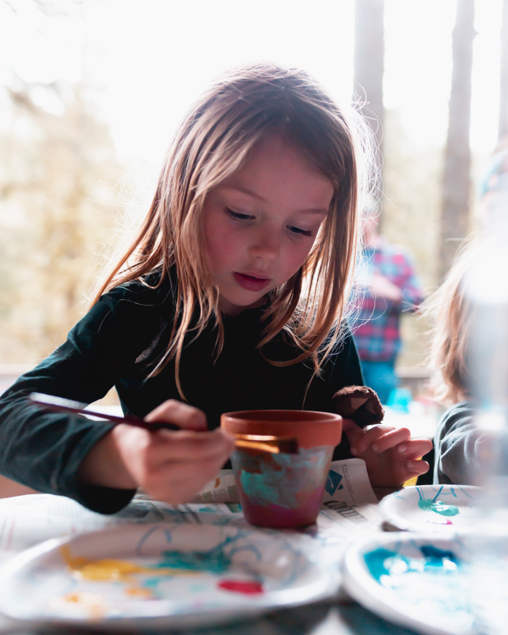 A child paints a flowerpot during a recent TreeSong class.