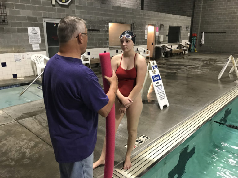 Camas and Washougal girls swimming and diving coach Mike Bemis talks to sophomore Natalie Kevis, who joined the Papermakers this season after transferring from Snohomish.