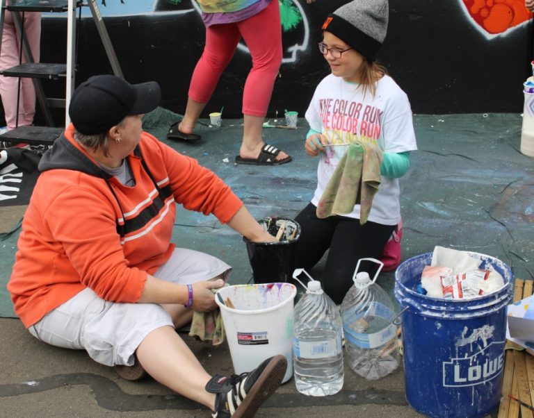 Jemtegaard Middle School (JMS) art teacher Dani Allen and JMS Club 8 art student Aubrey Kleiva clean paint brushes on Saturday, Oct. 12, in Washougal.