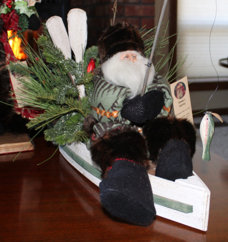 Each of the &quot;Sandy&#039;s Santas&quot; made by Washougal resident Sandy Havrelly are unique and have different personalities. Here, a fisherman Santa relaxes in his Pendleton wool jacket and fur hat while reeling in the catch of the day from his fishing boat.