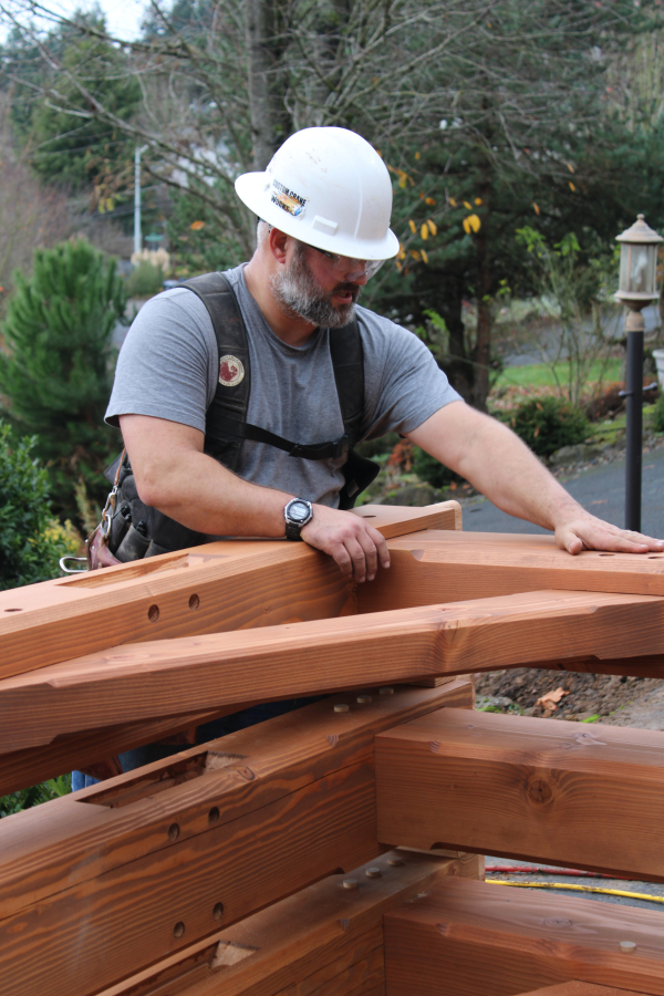 Darren Watson, of New Energy Works, stabilizes the corner of a solar canopy being constructed Nov. 18.