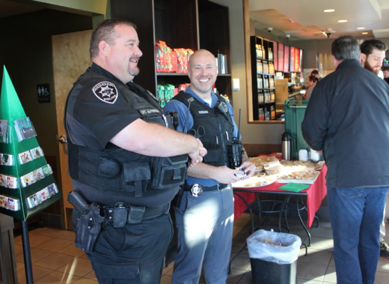 Washougal police officers Dan McPherson (left) and Kyle Kinnan (right) greet customers at the Washougal Starbucks at Third and &quot;C&quot; streets during the Nov.