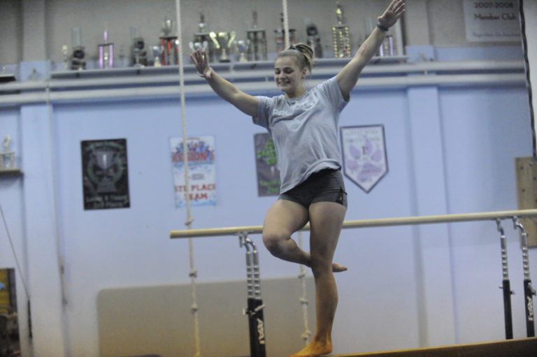 Sophomore Peyton Cody stops to smile at the Camas High School gymmnastics team&#039;s first meet of the year in Battle Ground on Dec. 7.