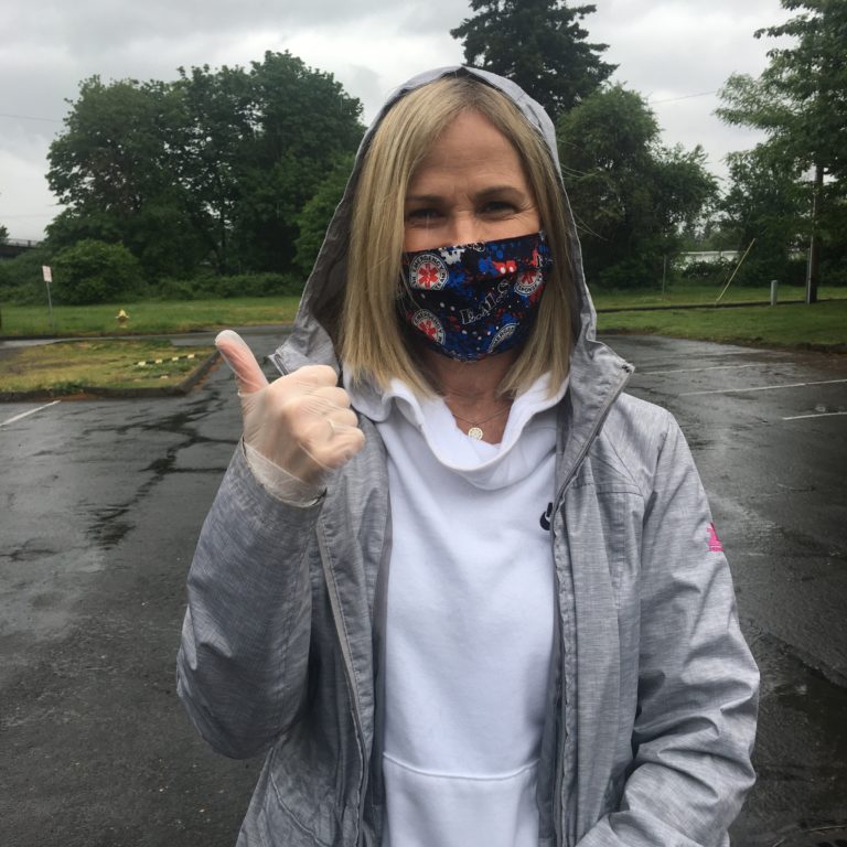 Colleen O’Neil, a Meals on Wheels People volunteer food-delivery driver, gives a “thumbs up” during her weekly food pickup in Washougal.