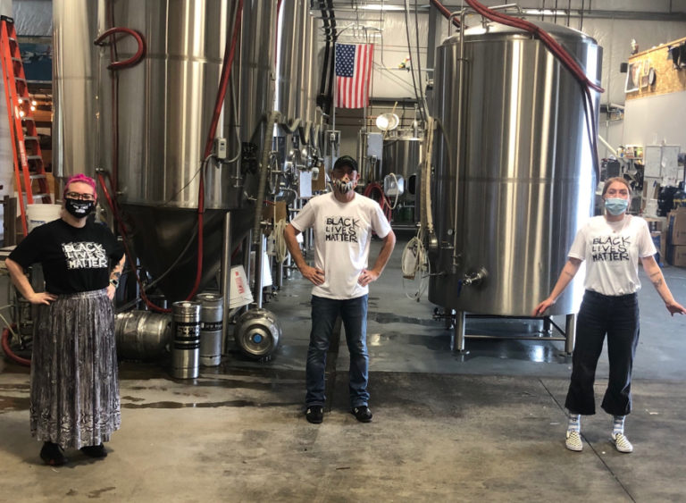 54-40 Brewing Company owner Bolt Minister (center) stands with employees in solidarity for the Black Lives Matter movement. Minister is planning a trivia event to raise funds for the National Association for the Advancement of Colored People (NAACP) and has vowed that his establishment will be an agent of change to combat systemic racism.