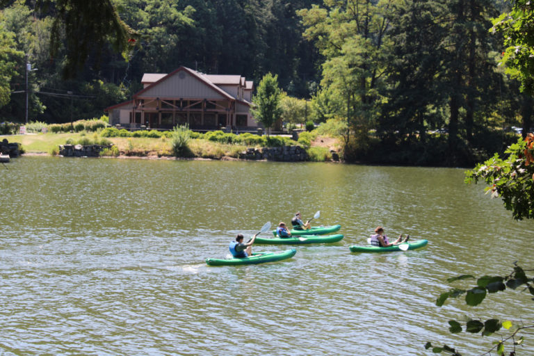 Kayakers paddle past the city of Camas' Lacamas Lake Lodge on Friday, July 31. Public health officials have warned since early June that toxic blue-green algae, which can kill pets and cause severe illness in humans, is present in Camas' Lacamas and Round lakes.