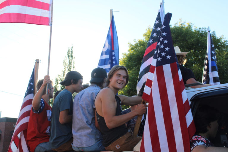 Young men riding in the back of a pickup truck that sped through downtown Camas dozens of times during a pro-police "Back the Blue" rally on Friday, Aug.