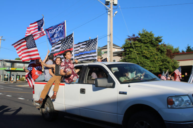 Young men sit on the side of a pickup truck heading west on Northeast Third Avenue in Camas on Friday, Aug. 28.