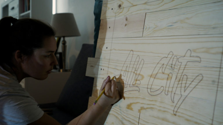 Contributed photo courtesy Jackie Gollbach 
 Washougal resident Jackie Gollbach draws on a wooden sign during the filming of the first video for her new YouTube channel, &quot;Nail Polish and Power Tools.&quot;
