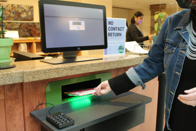 Camas Public Library Director Connie Urquhart demonstrates the library's no-touch book return on Friday, March 5, 2021.