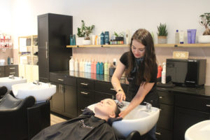 Christina Hendry (standing), a hair stylist at Moonlight Salon in Camas, washes Sydney McCormick's hair at the downtown Camas salon on June 11, 2021. (Photos by Kelly Moyer/Post-Record)