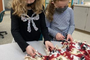 Washougal first-graders Quinn Henry (left) and Naomi Vest make a blanket for West Columbia Gorge Humane Society shelter animals at Cape Horn-Skye Elementary School in Washougal in December 2021. (Contributed photo courtesy of the Washougal School District)
