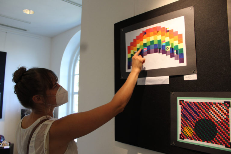 Hayes Freedom High School art teacher Miranda Wakeman browses student art during the opening night of the Second Story Gallery&#039;s new, two-month student art exhibit, &quot;Stepping Out,&quot; on Friday, July 1, 2022.