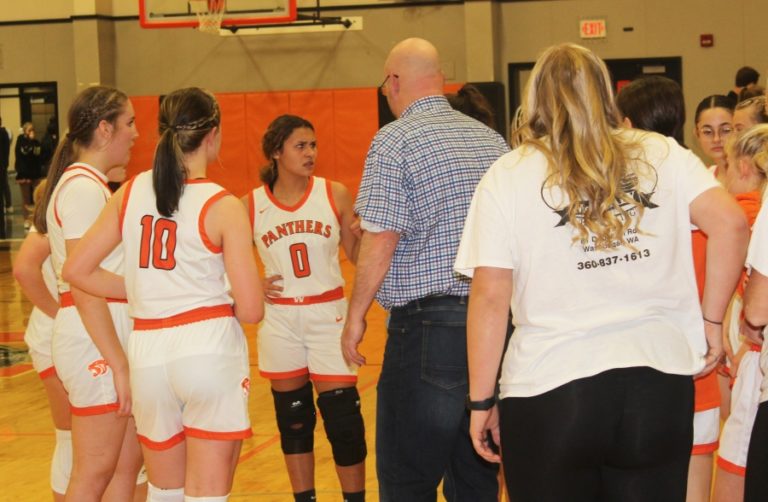 Washougal High School senior point guard Chloe Johnson (0) talks to the Panthers' coach, Tim Melcher, and teammates during the second half of Washougal's home game against Tumwater on Friday, Dec. 2, 2022.