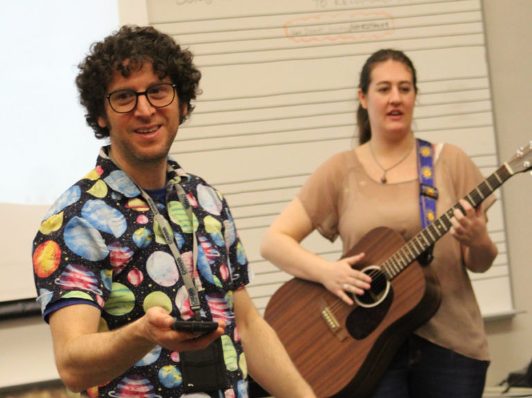 Camas High School choir teacher Ethan Chessin (left) instructs students during his first-period choir class on Friday, March 17, 2023, while visiting musician Becca Larsen (right) looks on.