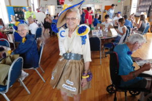 Camas historian Virginia Warren shows off her paper dress during the 2018 luncheon for current and former members of the Camas Days Royal Court in July 2018. (Post-Record files) 