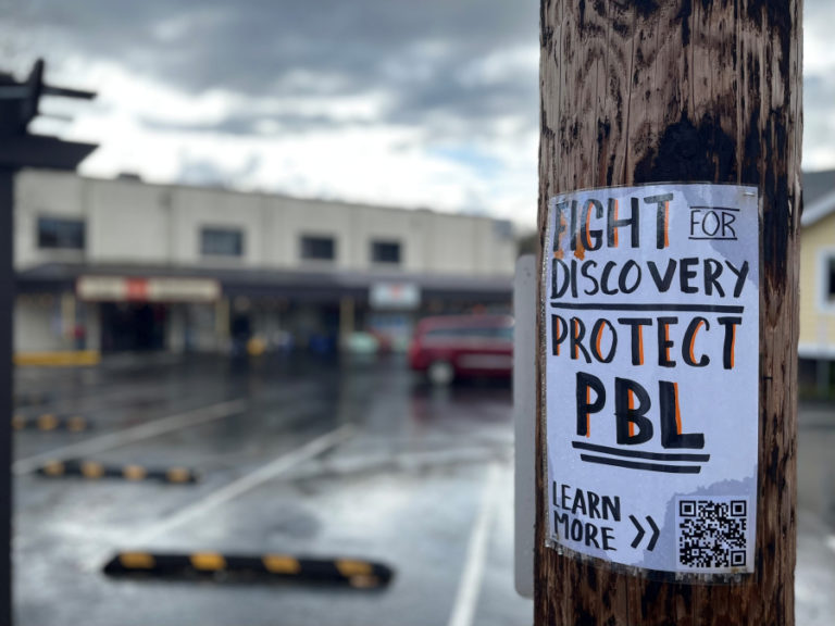 A sign asking the community to "Fight for Discovery" hangs  in downtown Camas on Friday, April 7, 2023.