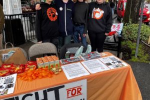 Discovery High School students (from left to right) Jax Goetzen, Angel Harp, Zimri Baxter and Hannah Cuffel-Leathers gather at a booth on the corner of Northeast Fourth Avenue and Northeast Cedar Street in downtown Camas during the Downtown Camas Association's First Friday event on April 7, 2023. The students are calling for the Camas School District to reconsider budget cuts that will impact their project-based learning high school. (Kelly Moyer/Post-Record)