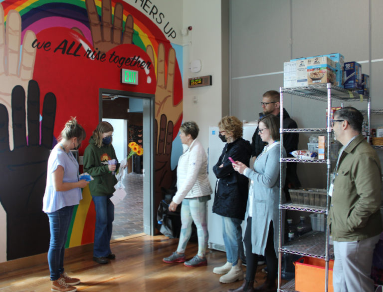 Camas School District administrators and staff, including Superintendent John Anzalone (far right) and Camas City Councilmember Marilyn Boerke (fourth from left) and Hayes Freedom High School art teacher Miranda Wakeman (far left) attend the unveiling of Hayes Freedom High School freshman Kindyl Moore (second from left)'s mural inside the Jack, Will and Rob Center, on Friday, April 21, 2023.