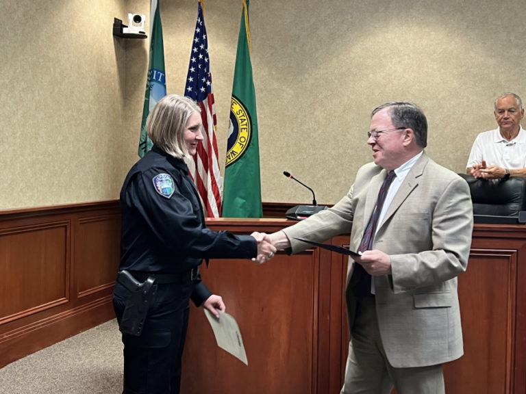 Camas Mayor Steve Hogan (center) shakes hands with new Camas Police Chief Tina Jones (left) as Camas City Councilman and former police chief Don Chaney (right) following Jones' swearing-in on Monday, July 3, 2023, at Camas City Hall.