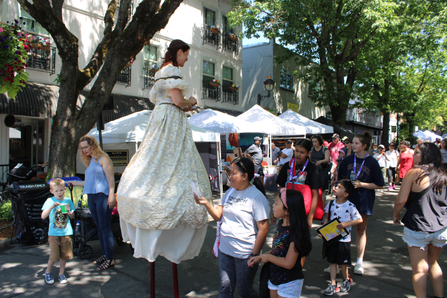 A stilt-walker passes out information about the city of Camas' free 2023 Movies in the Park events on Friday, July 21, 2023, during the 2023 Camas Days celebration held  the third weekend in July throughout downtown Camas. (Kelly Moyer/Post-Record)