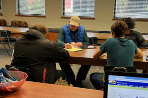 Community-School Partnership volunteer John Neumann works with a small group of Washougal High School freshmen in 2023.