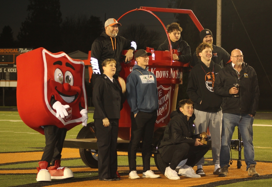 Washougal High School senior Holden Bea (crouching, center) holds a trophy and gathers with his 