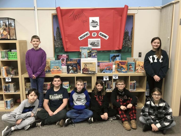 Hathaway Elementary School fifth-graders gather in front of books they read during the 2024 Passport to Reading program.