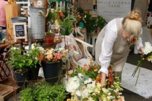 Pam Richey Curtis, owner of Belle Flower Farm, arranges flowers at the 2022 Camas Vintage & Art Faire. (Photo courtesy of Belle Flower Farm)
