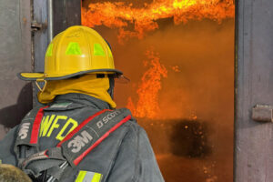 Washougal City Councilwoman Tia Robertson enters a burning building during the Washington State Council of Firefighters' Fire Ops 101 event, held March 22, 2024, at the Volpentest Hammer Federal Training Center in Richland, Wash. (Contributed photo courtesy of Tia Robertson)