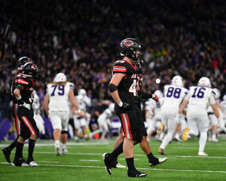 Camas senior Nikko Speer, center, and other teammates walk off the field as Sumner celebrates their game-winning field goal Saturday, Dec. 7, 2024, after the Papermakers’ 27-24 loss to Sumner in the 4A State Championship game at Husky Stadium.