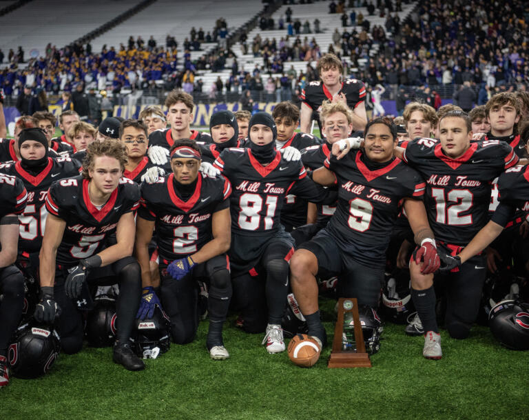 Camas players pose for a photo with the runner-up trophy Saturday, Dec. 7, 2024, after the Papermakers’ 27-24 loss to Sumner in the 4A State Championship game at Husky Stadium.